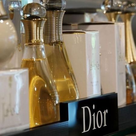 Eine Auslage mit eleganten Parfümflakons mit goldenen Akzenten und weißer Verpackung, auf der der Name Dior deutlich zu sehen ist