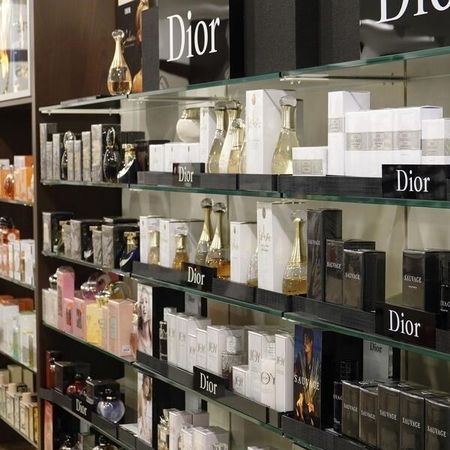 Eine Ausstellung von Parfüms in Glasregalen mit verschiedenen eleganten Flakons und Verpackungen