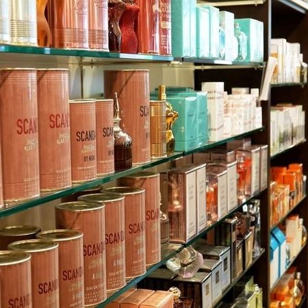 Ein gut bestücktes Regal mit verschiedenen duftenden Produkten, darunter Parfums in bunten Flaschen und elegant gestalteten Verpackungen