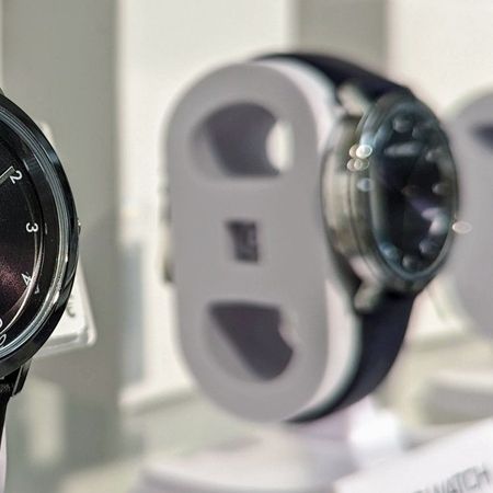 Eine Nahaufnahme einer eleganten schwarzen Armbanduhr mit silbernen Akzenten, zwischen anderen Uhrenmodellen