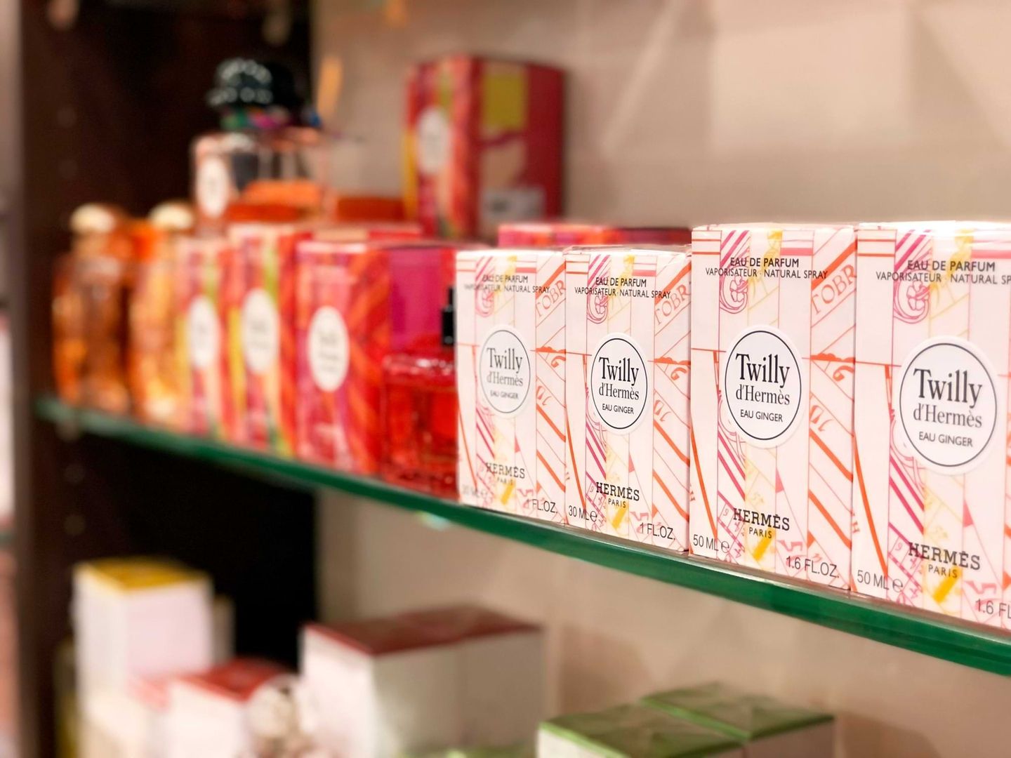 Eine Auslage mit bunten Parfümschachteln auf einem Regal