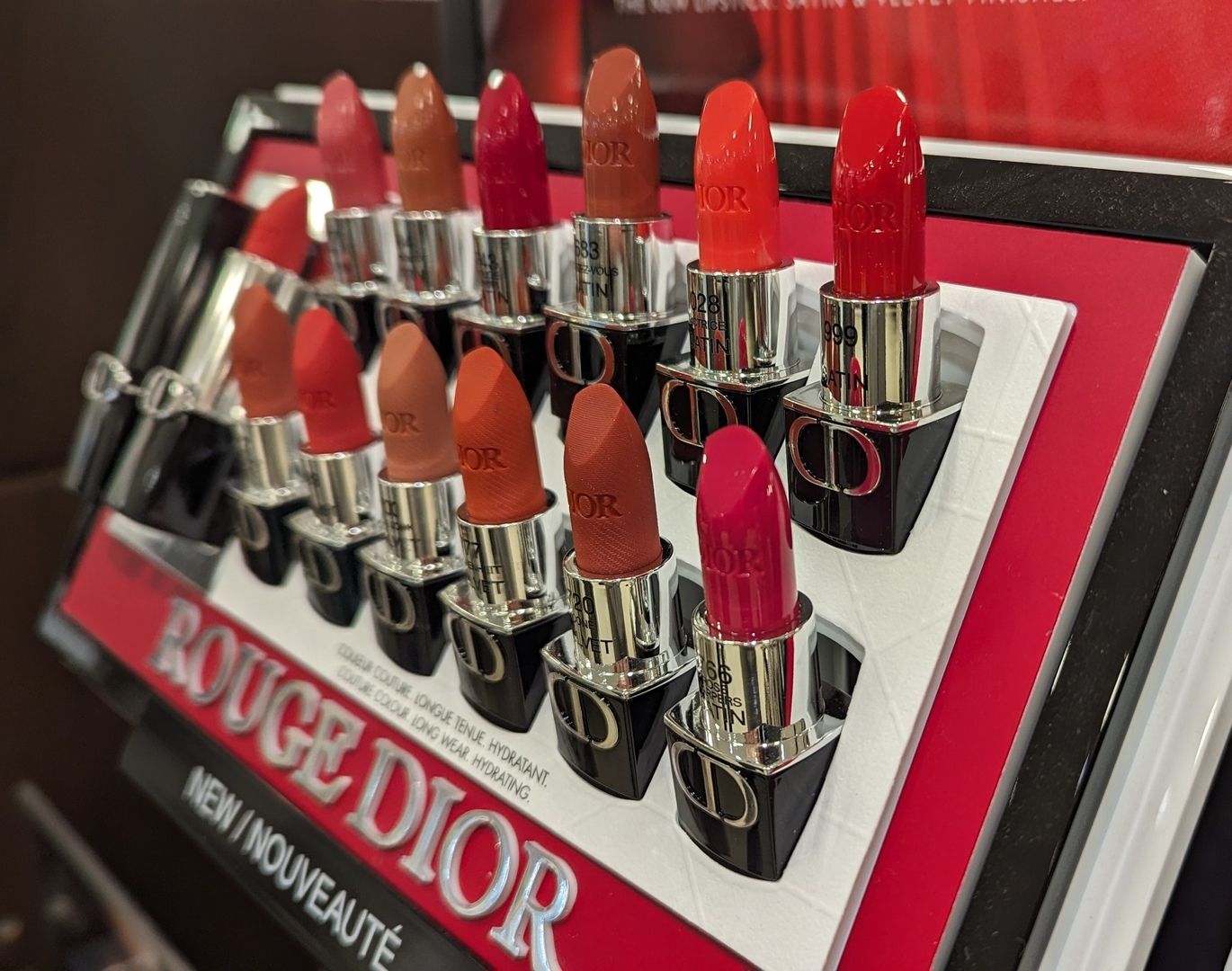 Eine Auslage mit Dior Rouge-Lippenstiften in verschiedenen Rot- und Nude-Tönen