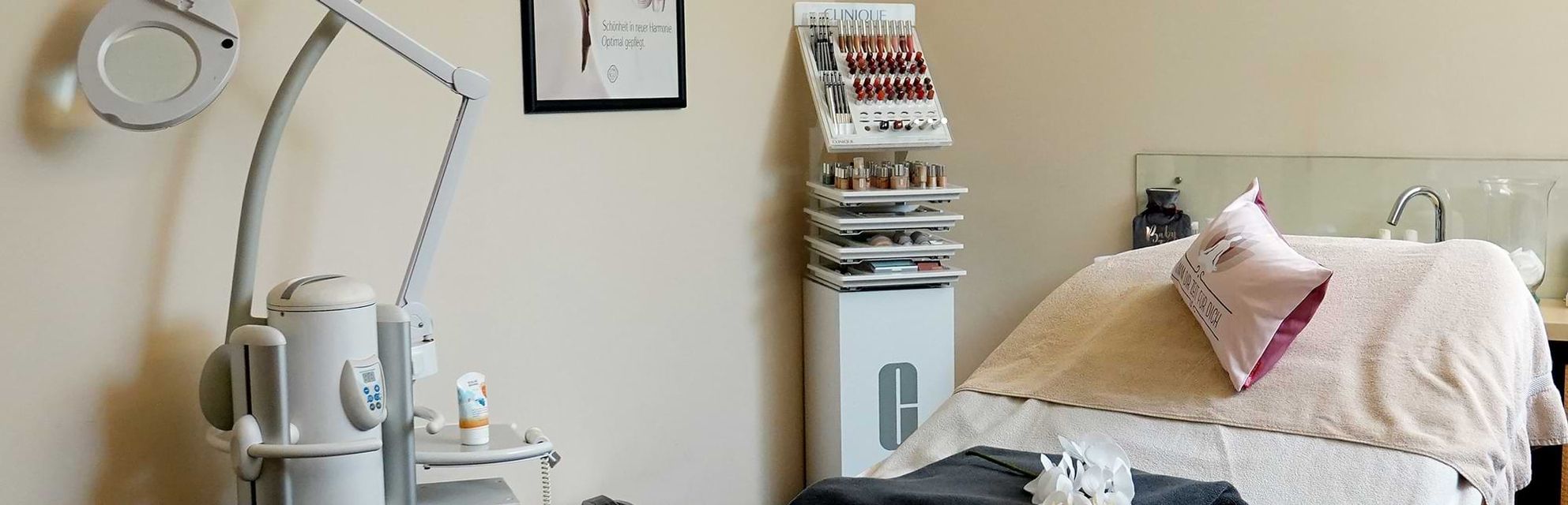 Raum für Schönheitsbehandlungen mit einem Gesichtsbett, einer Vergrößerungslampe, Hautpflegeprodukten und einer Make-up-Ausstellung